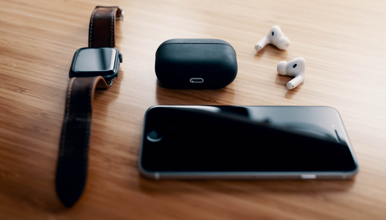 A sleek smartwatch, wireless earbuds, and smartphone showcasing the elegance of contemporary technology.